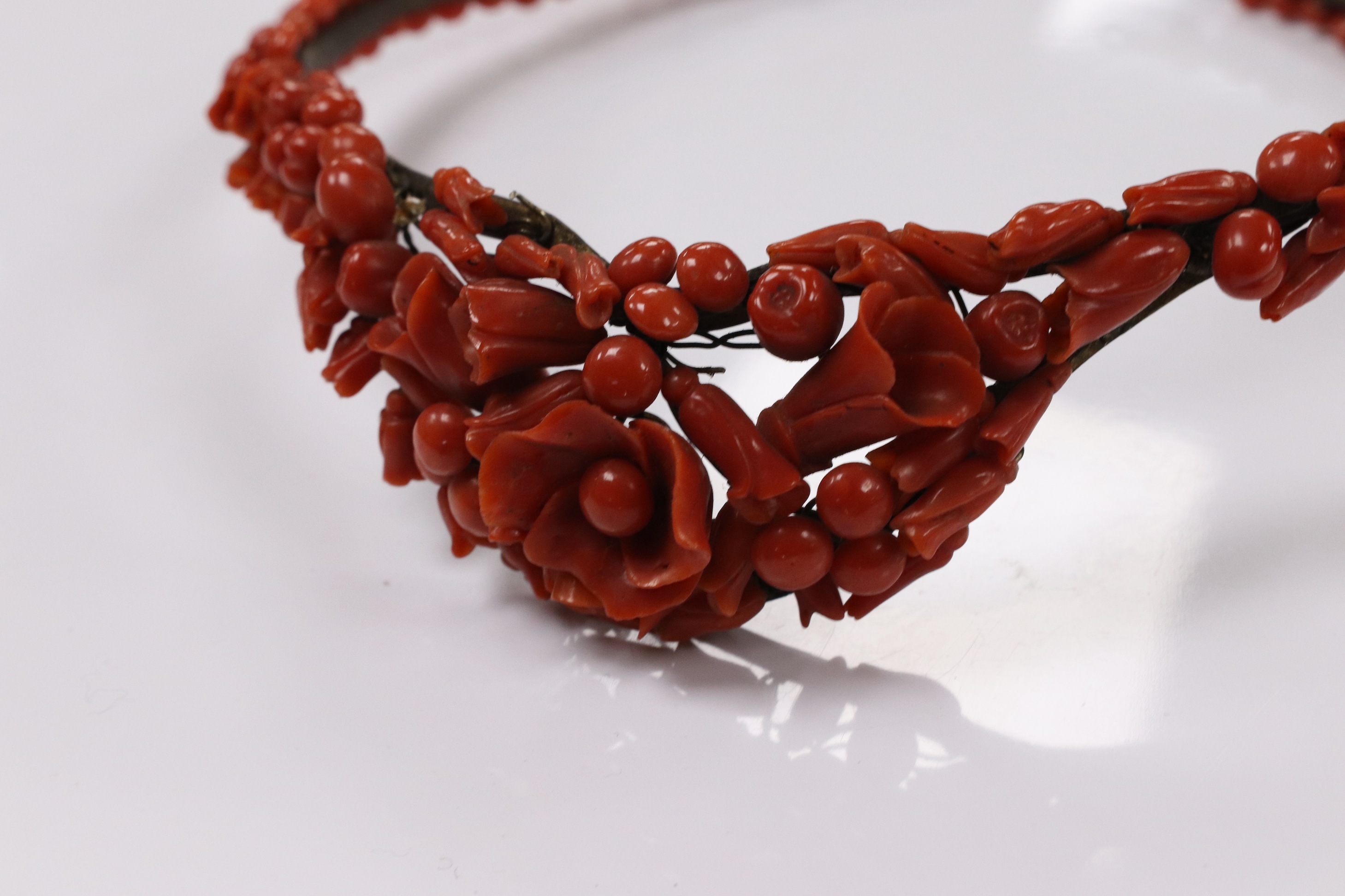 A 19th century base metal and coral bead floral designed tiara, approximately 40cm. Condition - poor to fair (some coral detached pieces in a small bag)